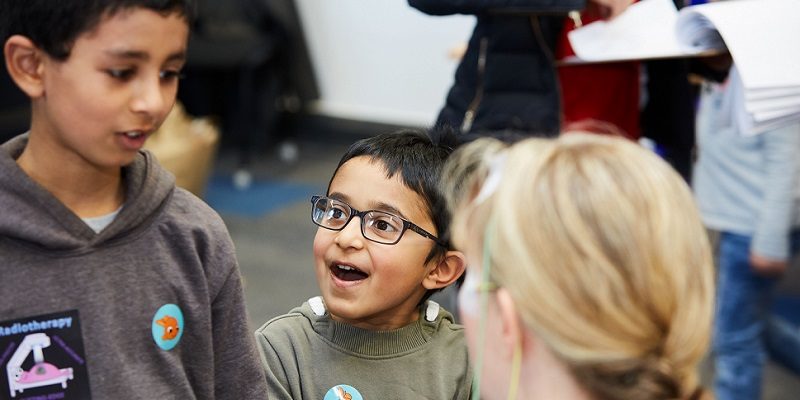 Two children listening to a an adult