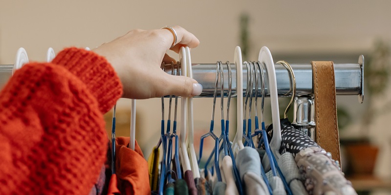 A photograph of a clothes rail with second hand clothes on
