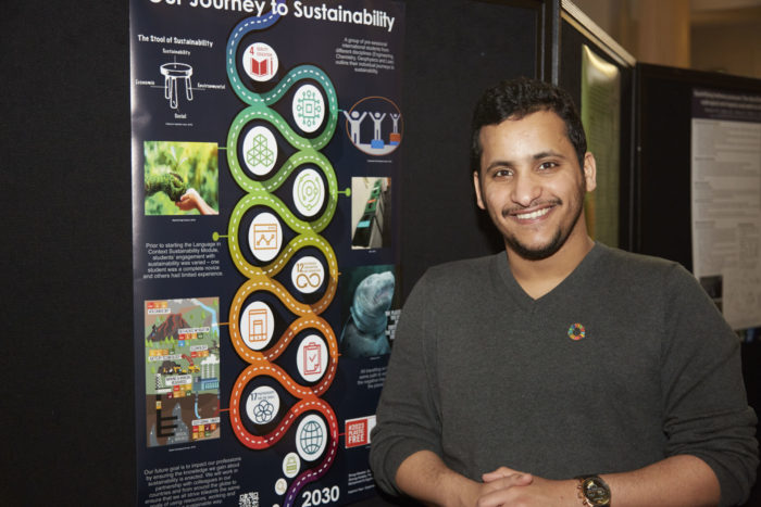 A person standing in front of poster display in the Parkinson Court during Student Sustainability Research Conference