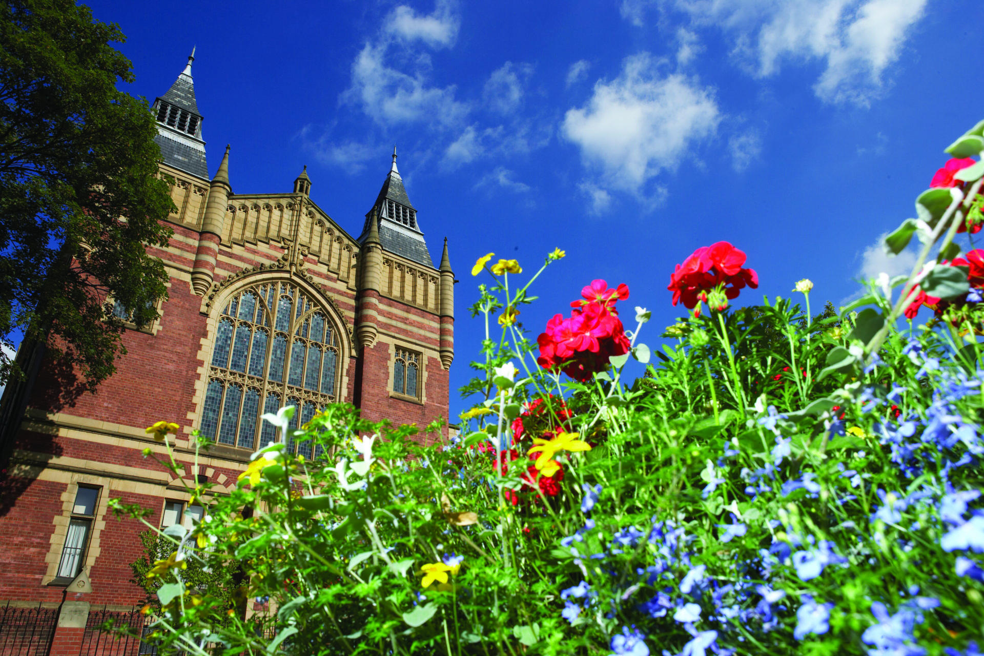 Flowers in front of a blue sky and the Great Hall at the University of Leeds