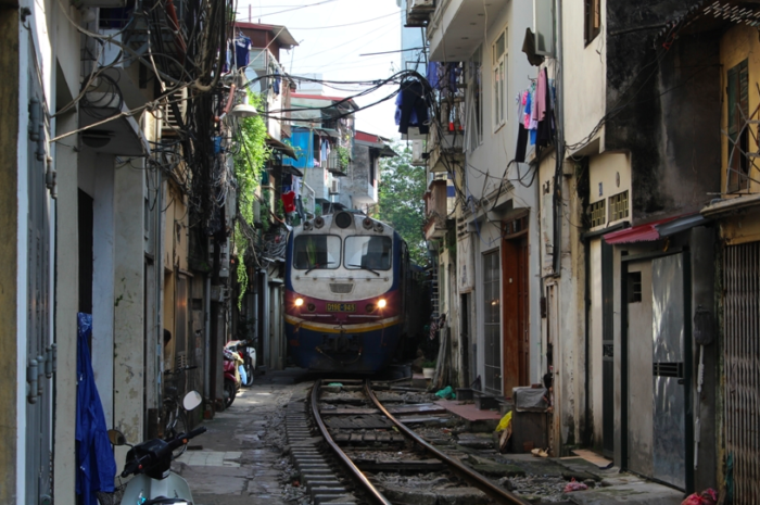 Picture of train travelling through a narrow street in downtown Hanoi, Vietnam