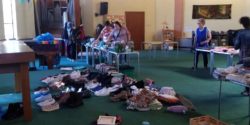 An image showing donated clothes and shoes displayed on the floor and tables at free shops