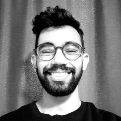 A photo of Student Sustainability Architect Raj smiling at the camera in a black and white photo. Raj has a short dark beard, glasses and a short haircut