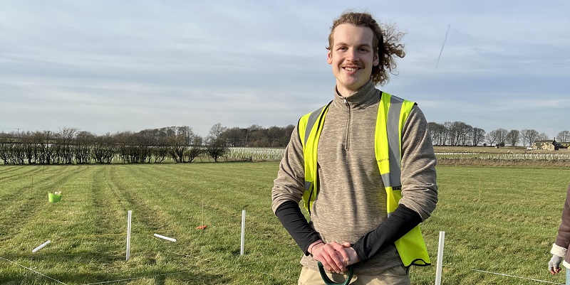 Photograph of Sam wearing a yellow high vis at the Gair Wood site