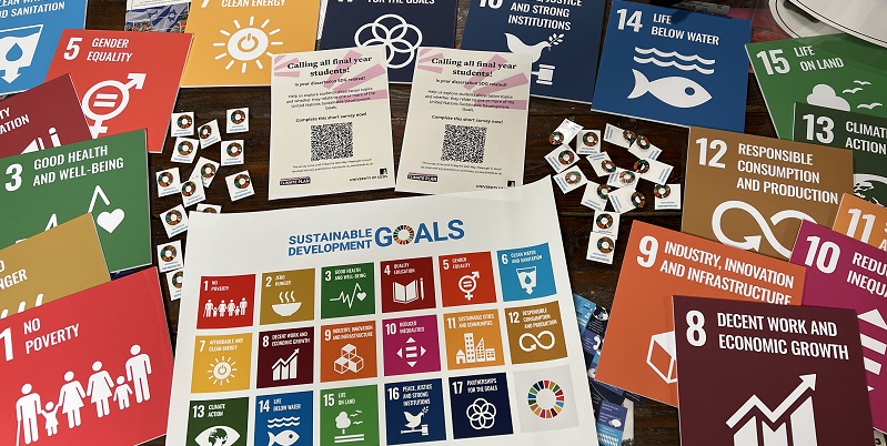 A table with tiles, badges and a poster of the Sustainable Development Goals.