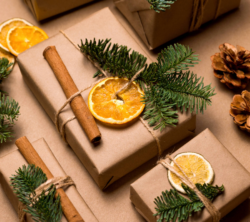 Christmas gifts adorned with a cinnamon stick and a dried orange slice. 
