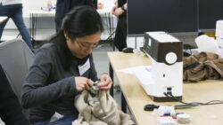 A student fixes a garment with a sewing machine.