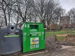 A bright green clothing donation bank and a grey glass recycling bank