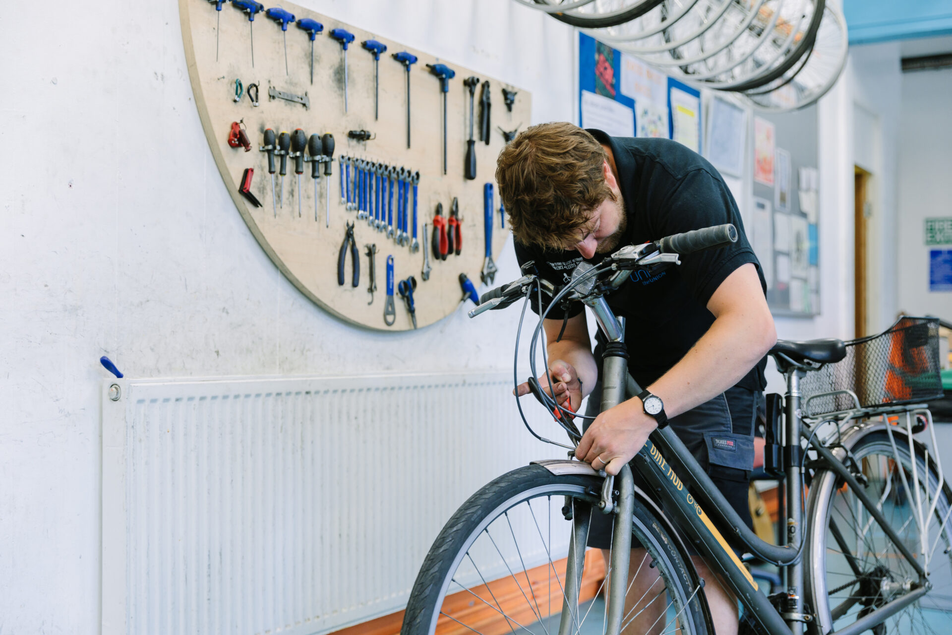 A bike hub staff member is fixing brakes on a bike