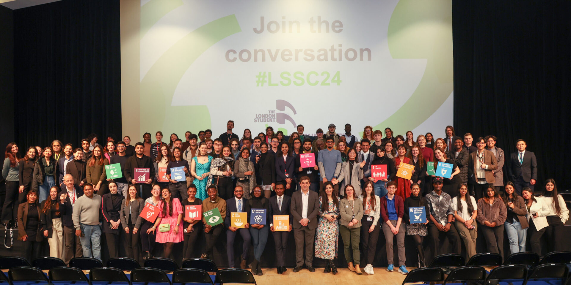 A group of students are gathered in front of a screen at the London Student Sustainability Conference.