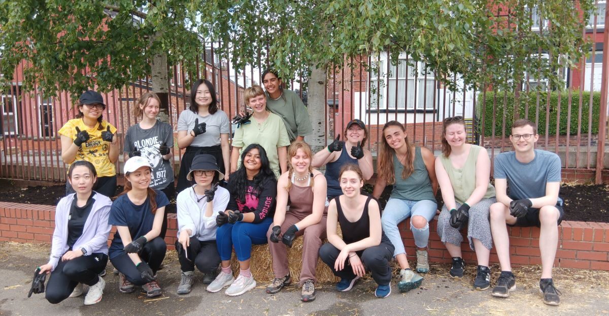 A group of volunteers sat under a tree at Brudenell Primary School.