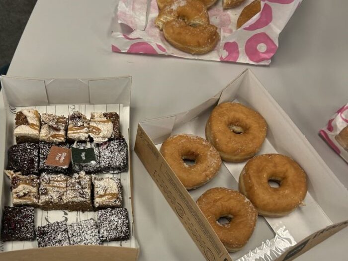 A box with sweet treats in including 4 doughnuts.