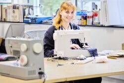 Student Sustainability Architect, Eleanor Smith, sitting in front of a sewing machine.